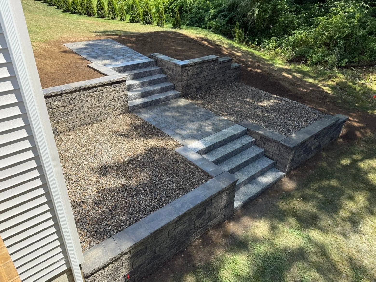 Finished retaining wall holding hillside — side view